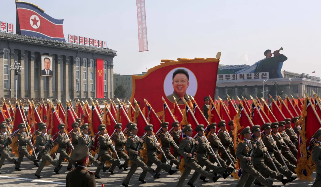 North Korean army marching in Pyongyang, carrying banners featuring Kim Il-Sung, the founding father of North Korea